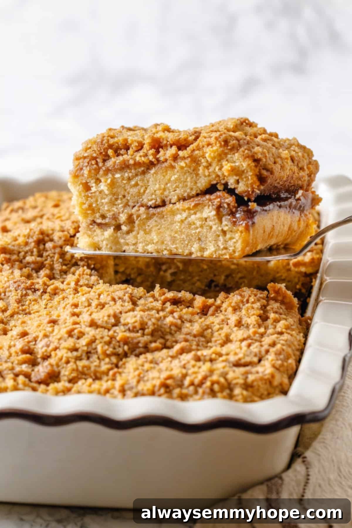 Spatula lifting slice of vegan coffee cake from baking dish.