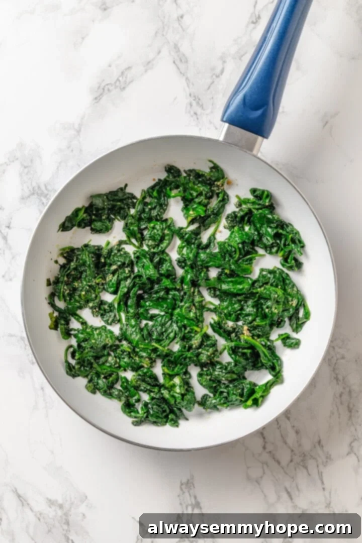 Spinach sautéed in a skillet, releasing its earthy aroma and vibrant green color.