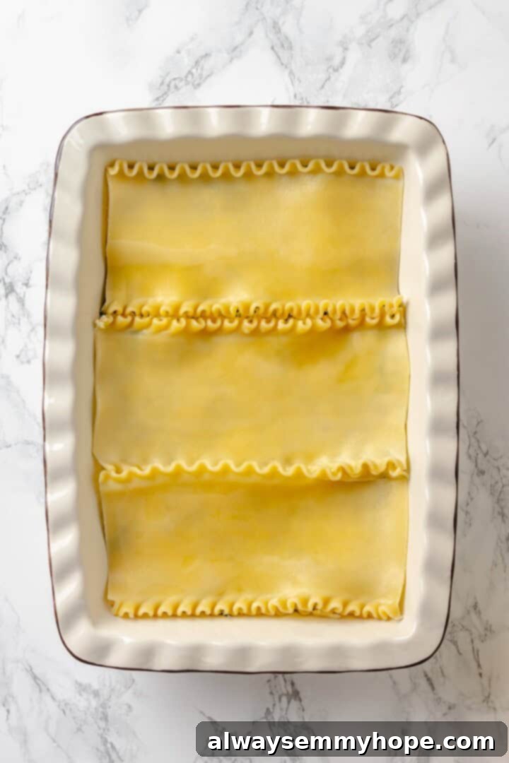 Lasagna noodles carefully arranged in a baking dish, creating a sturdy foundation for the layers of deliciousness to come.