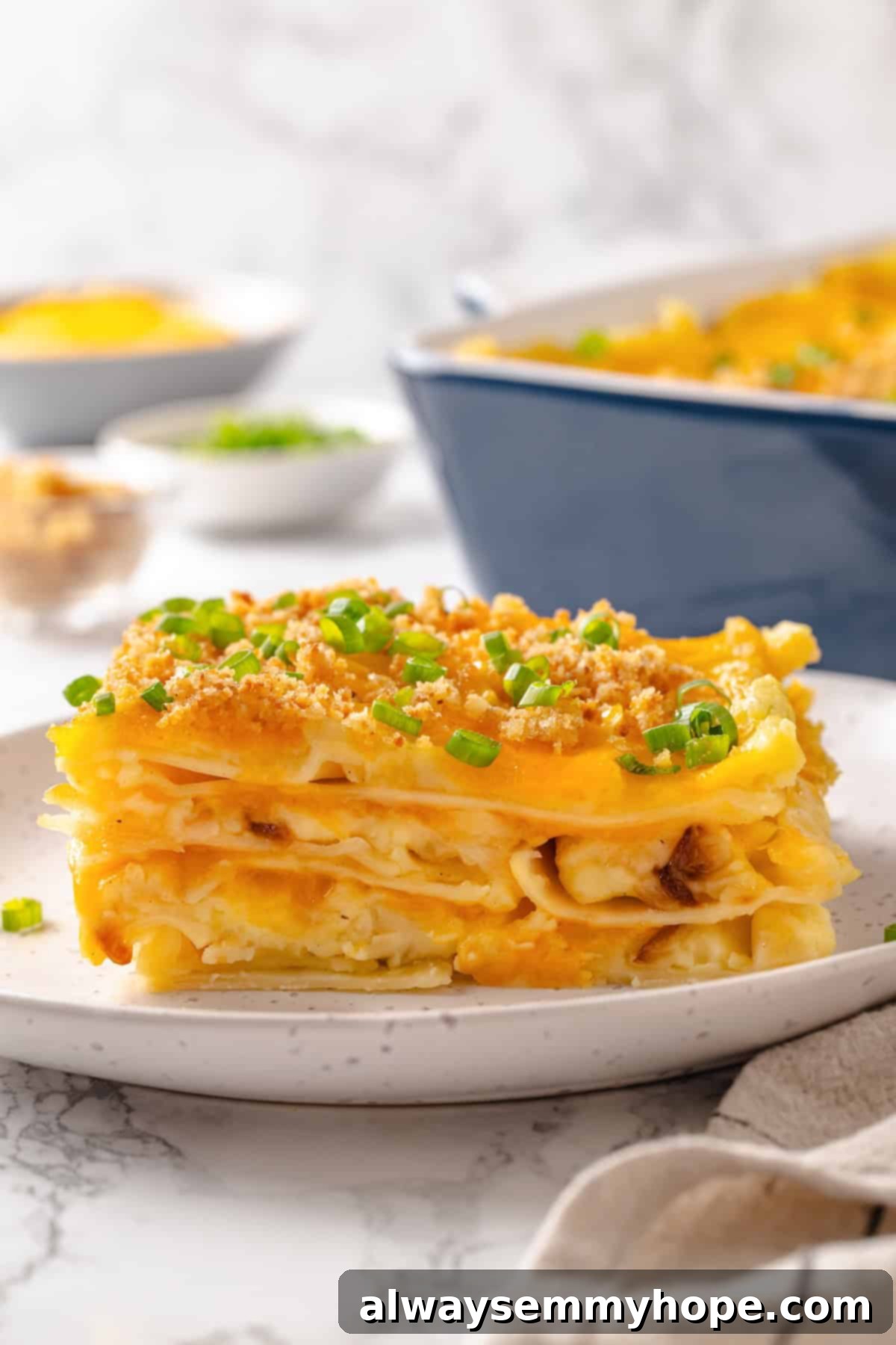 Slice of vegan pierogi casserole on a plate, garnished with green onions.