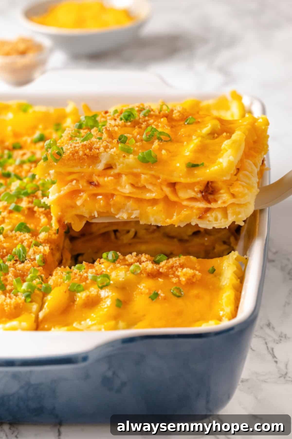 Spatula lifting a slice of vegan pierogi casserole from the dish.
