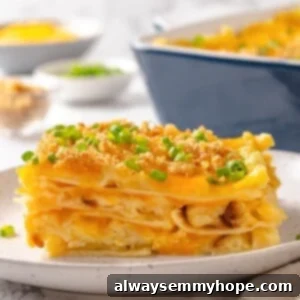 Slice of pierogi casserole on plate with green onions for garnish.