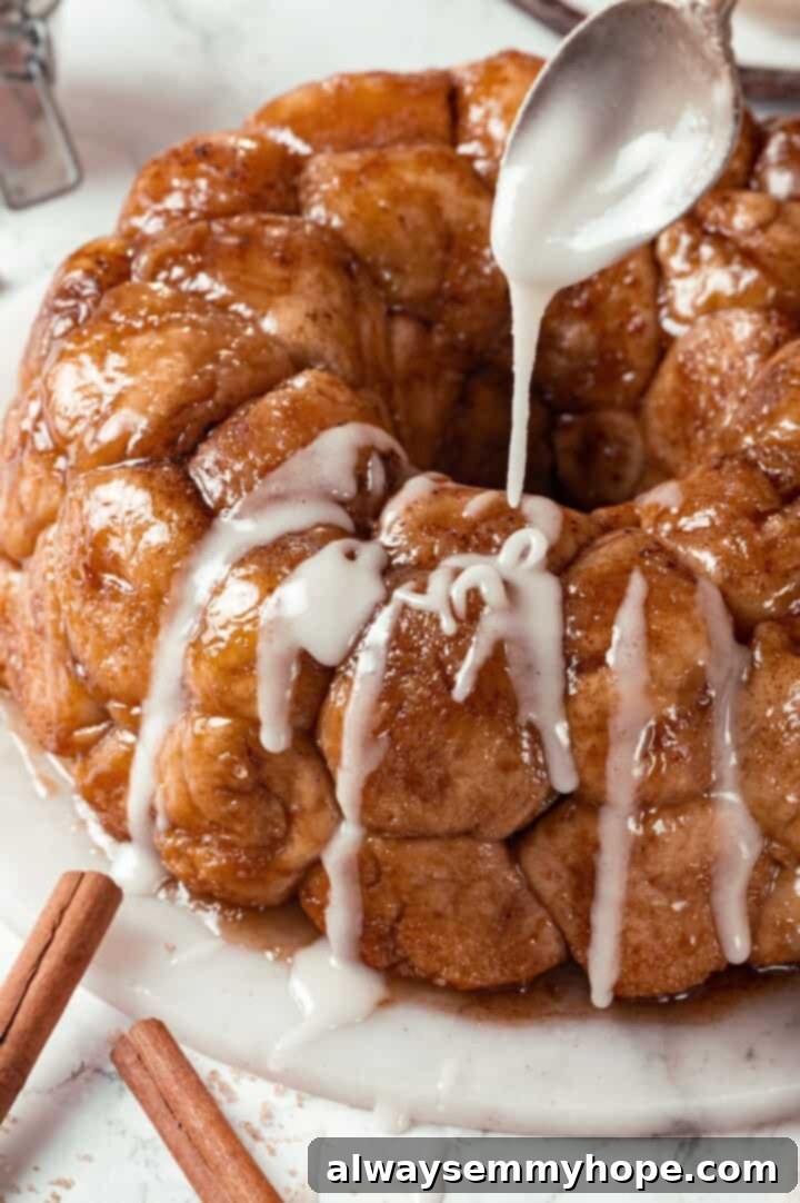 A spoon drizzling glaze over freshly baked vegan monkey bread, enhancing its sweetness and visual appeal.