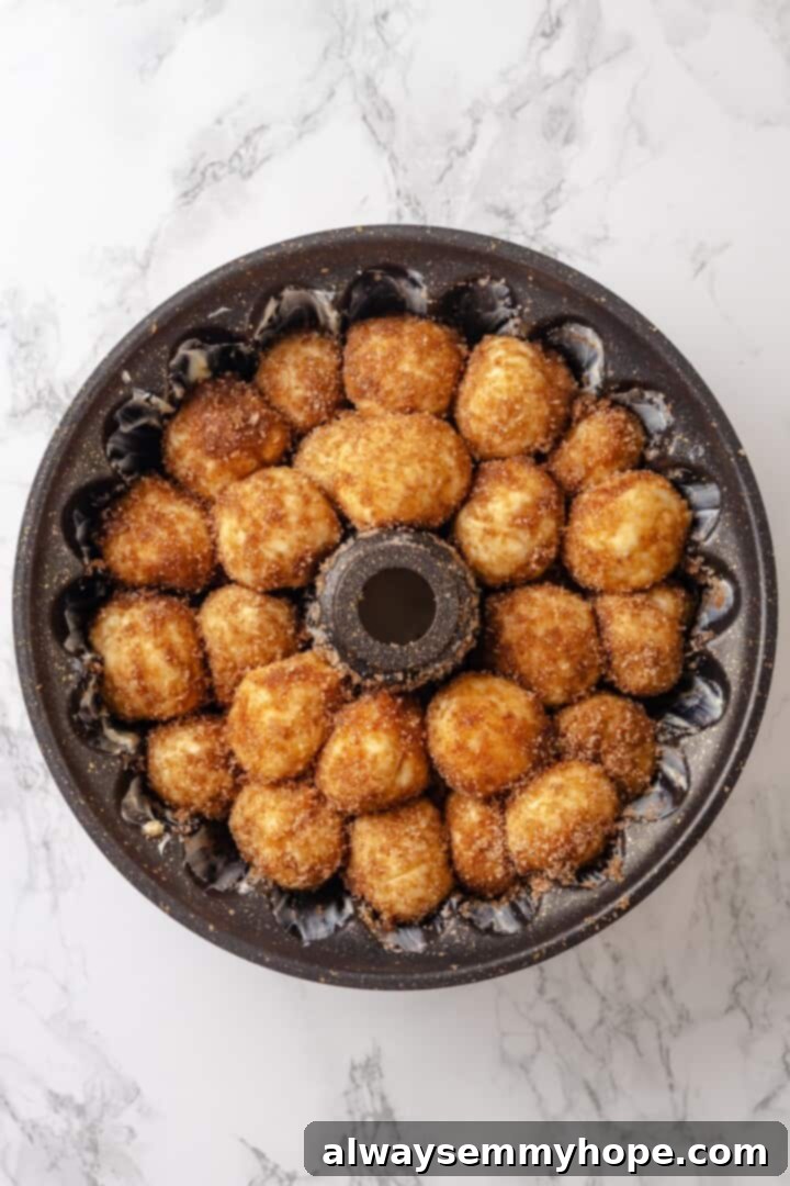 Vegan monkey bread dough balls layered in a bundt pan before their second rise, showing their even distribution.