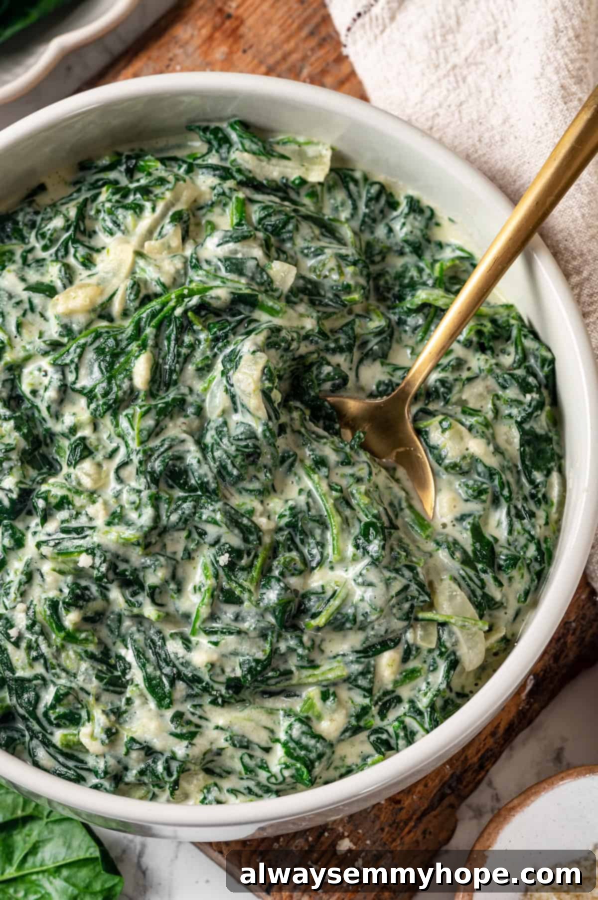 Bowl of vegan creamed spinach with a spoon.