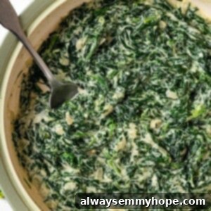Skillet of vegan creamed spinach with spoon inside.