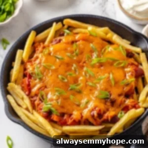 Skillet of chili cheese fries with scallions
