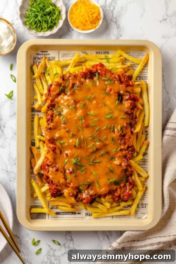 Vegan chili cheese fries on parchment lined baking sheet