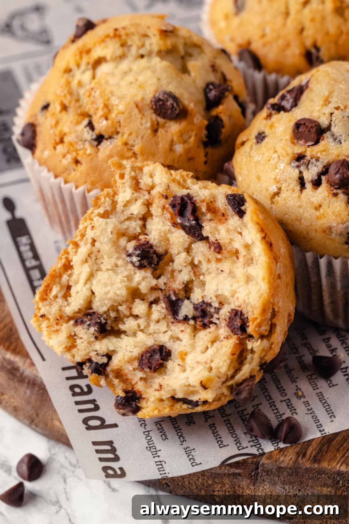 Vegan chocolate chip muffin broken in half to show tender crumb