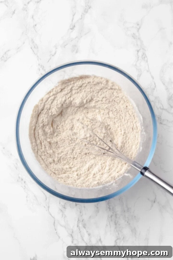 Dry ingredients for vegan muffins in a bowl with a whisk