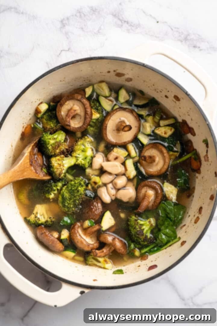 Adding Roasted Vegetables and Broth to Dutch Oven