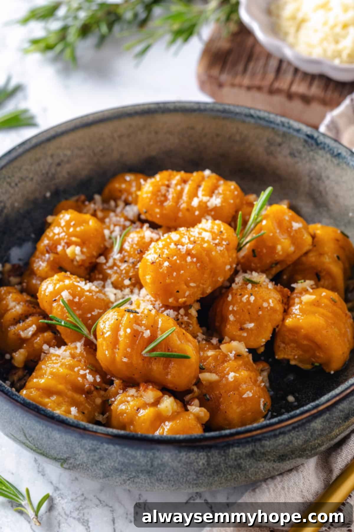 Bowl of vegan sweet potato gnocchi with rosemary garlic butter sauce.