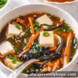 Spoonful of vegan miso tofu soup in bowl.