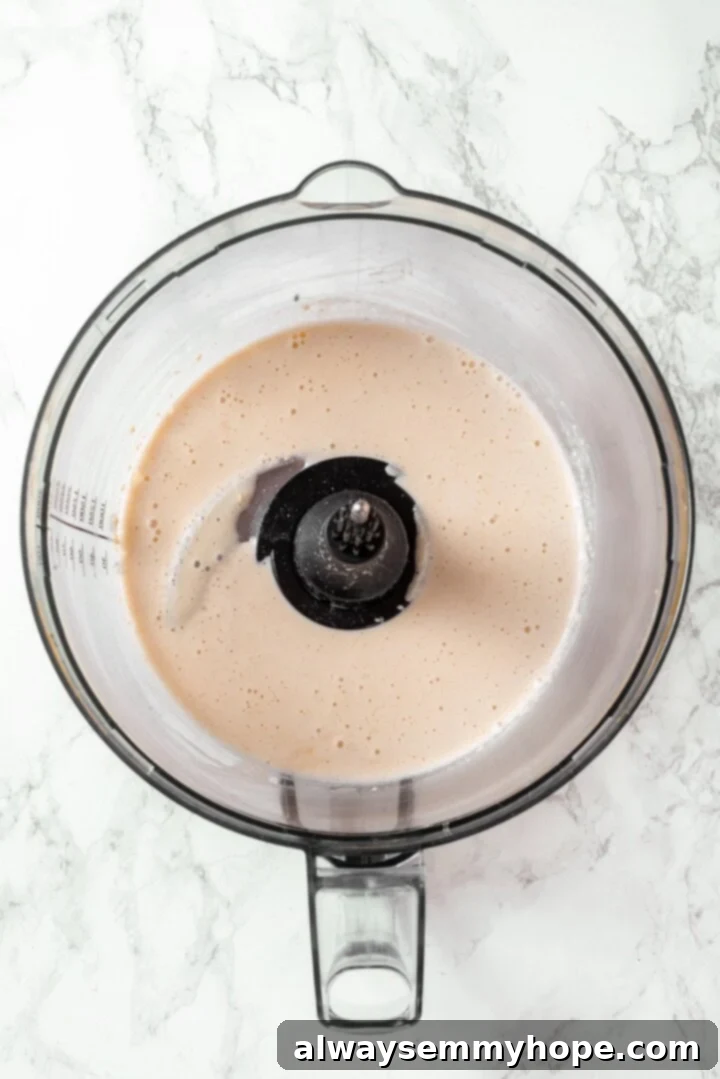 Liquid ingredients for vegan salami being processed in a food processor.