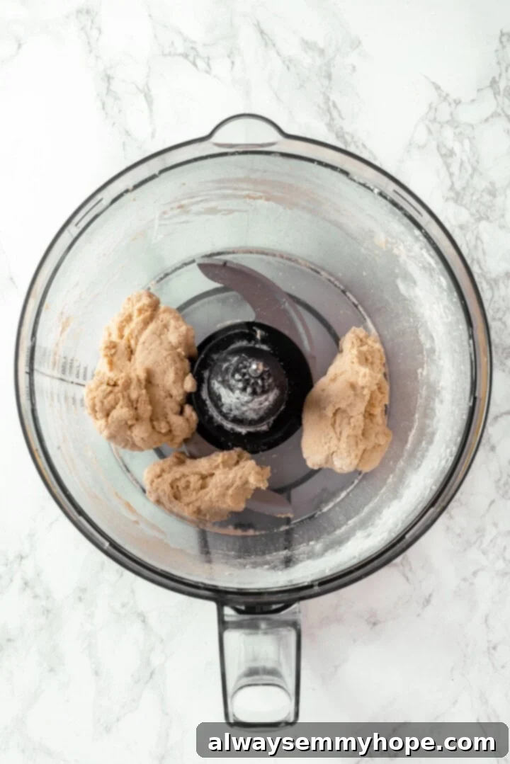 Salami dough being mixed in a food processor until it forms a cohesive ball.