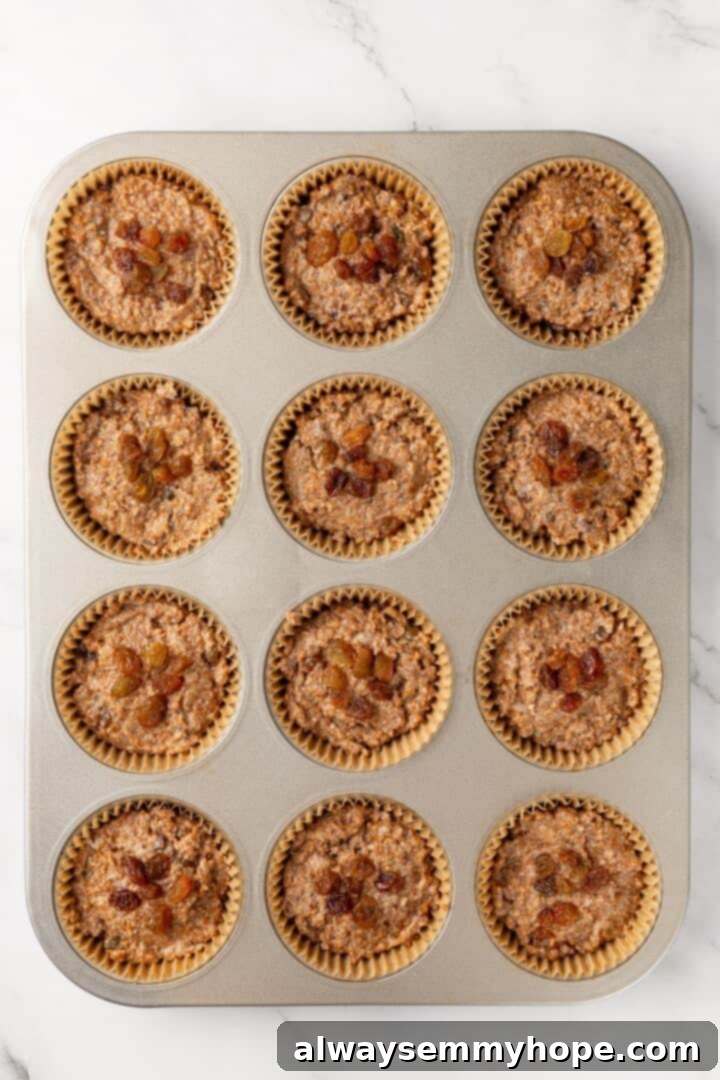Unbaked cinnamon raisin bran muffins in a muffin pan.