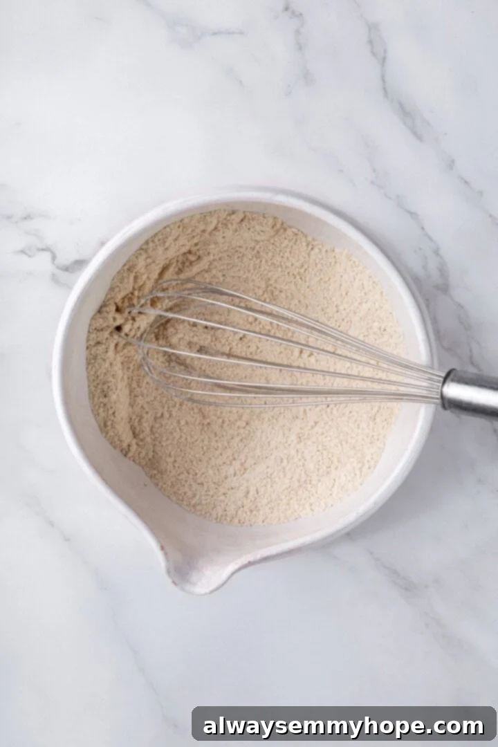 Whisking together dry ingredients in a bowl.