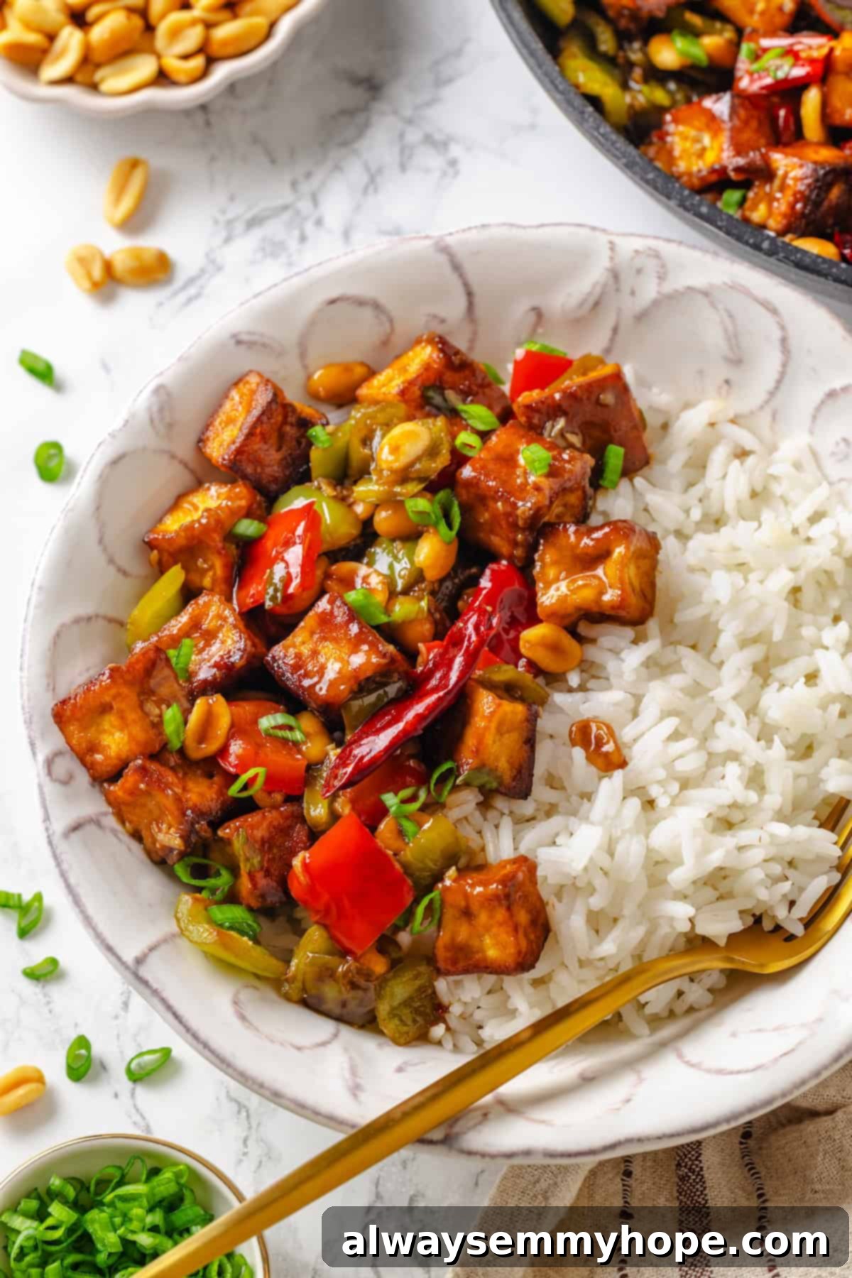 Bowl of Kung Pao Tofu with rice and a fork
