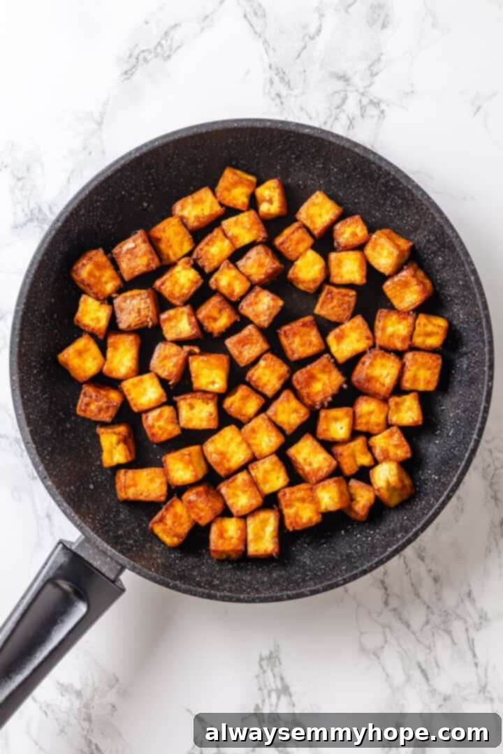 Crispy tofu frying in a skillet