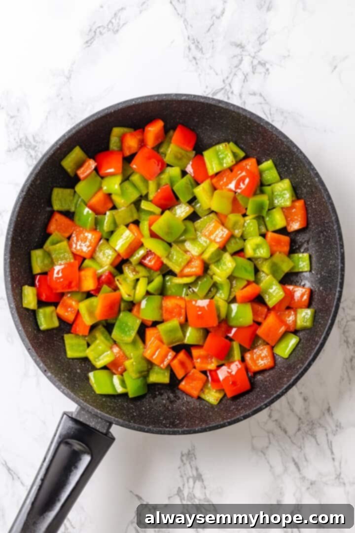 Stir-frying red and green bell peppers in a skillet