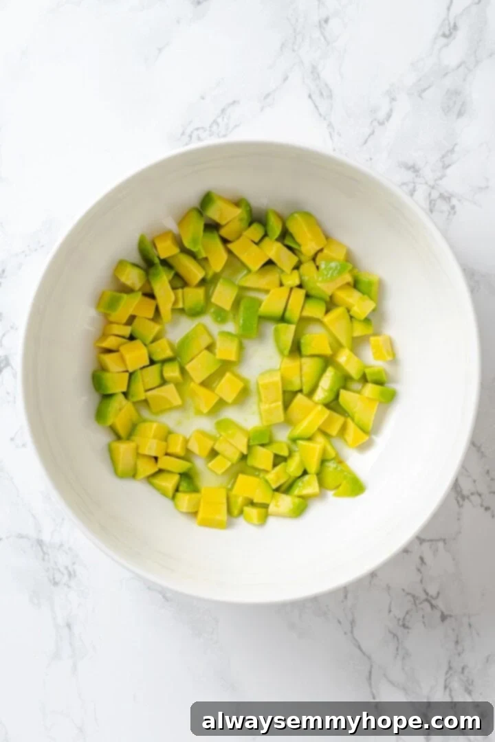 Fresh avocado cubes tossed with lime juice in a bowl.