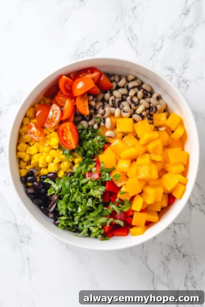 A bowl filled with colorful vegetables, beans, and cilantro.