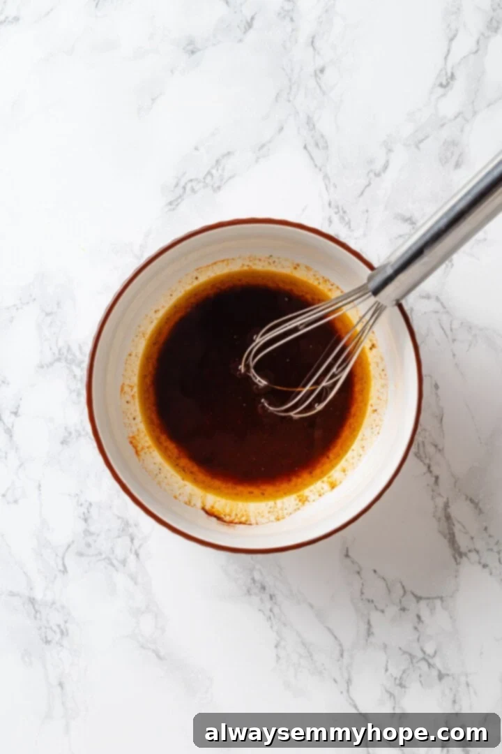 A whisk mixing the ingredients for red wine vinaigrette.