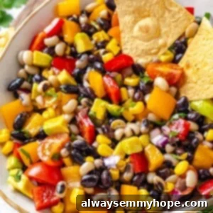 Two tortilla chips in bowl of cowboy caviar, ready to dip!