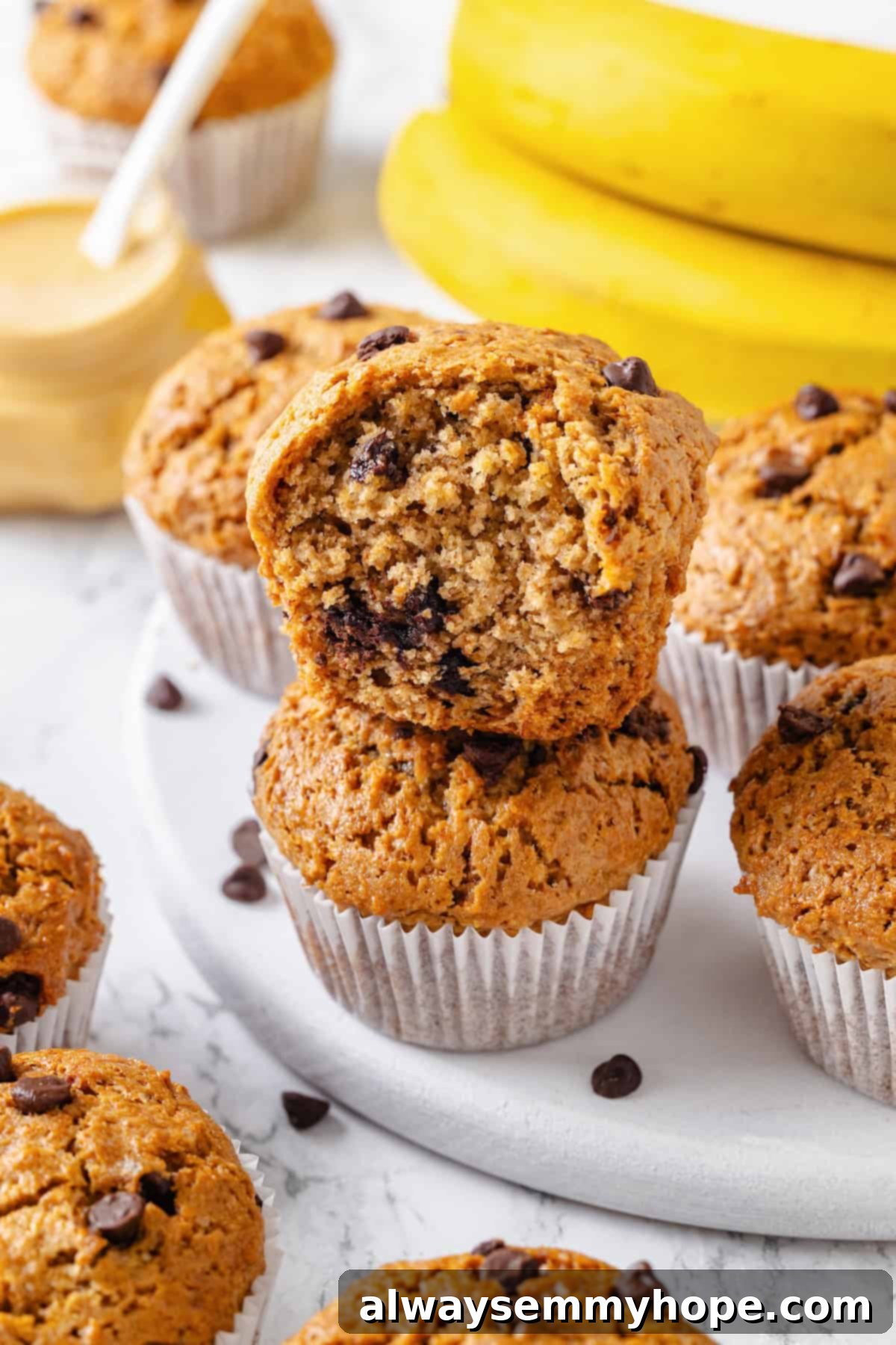 Peanut Butter Banana Bliss Muffins 11 Bitten peanut butter banana muffin stacked on another muffin