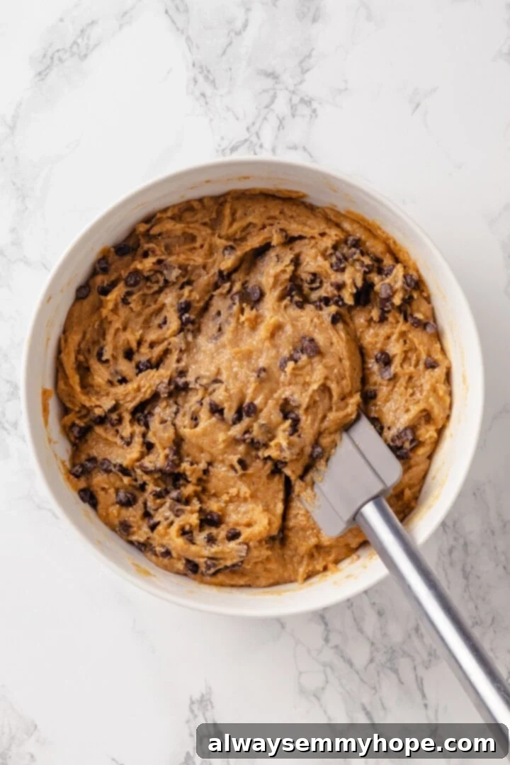 Peanut Butter Banana Bliss Muffins 7 Batter for peanut butter banana muffins in bowl with rubber spatula