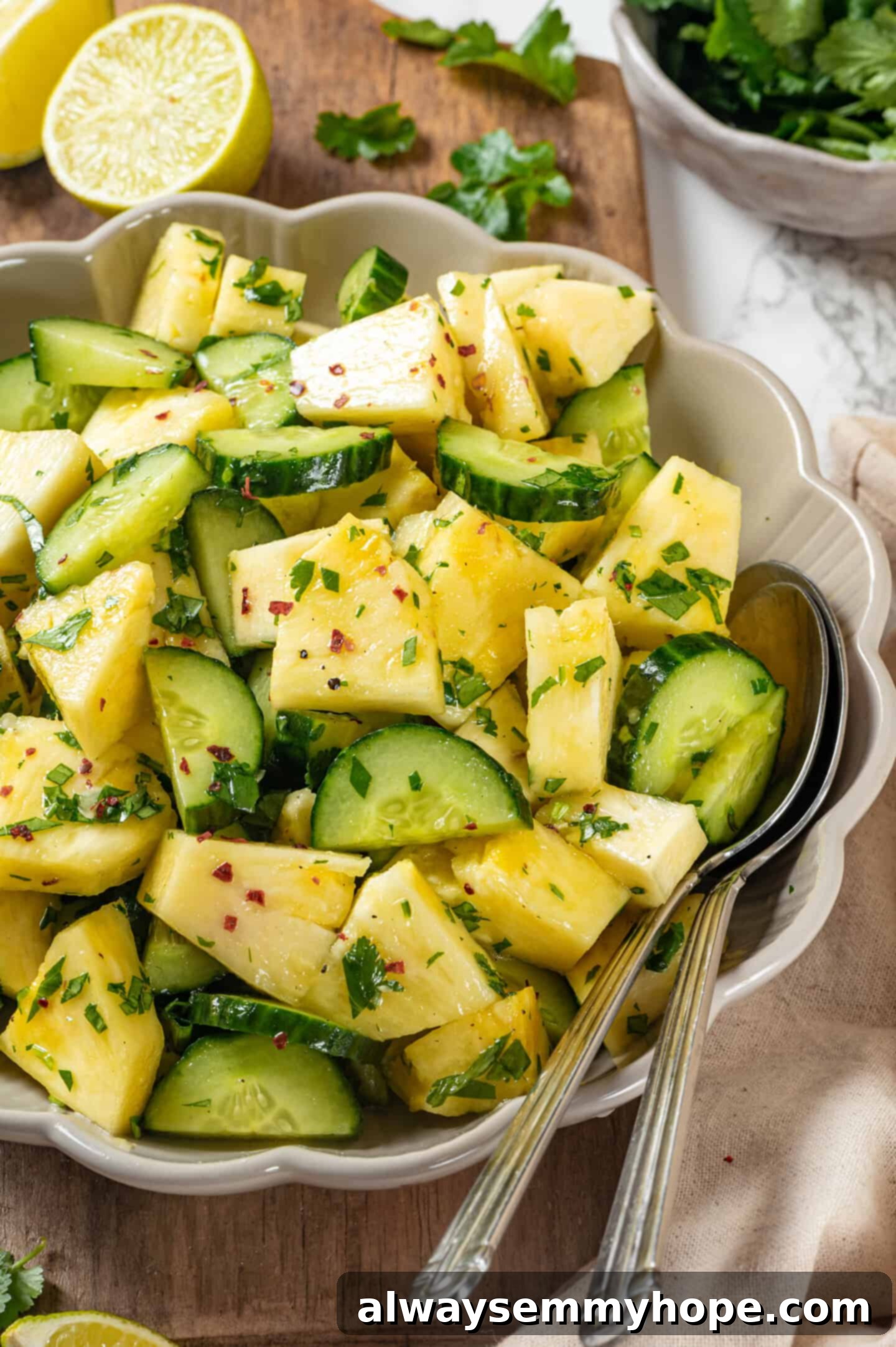 Pineapple Cucumber Refresher 8 Two spoons in a bowl of pineapple cucumber salad, inviting you to dig in and enjoy.