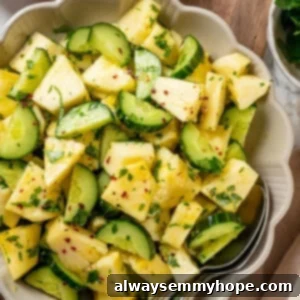 Pineapple Cucumber Refresher 9 Pineapple cucumber salad in bowl with two spoons.