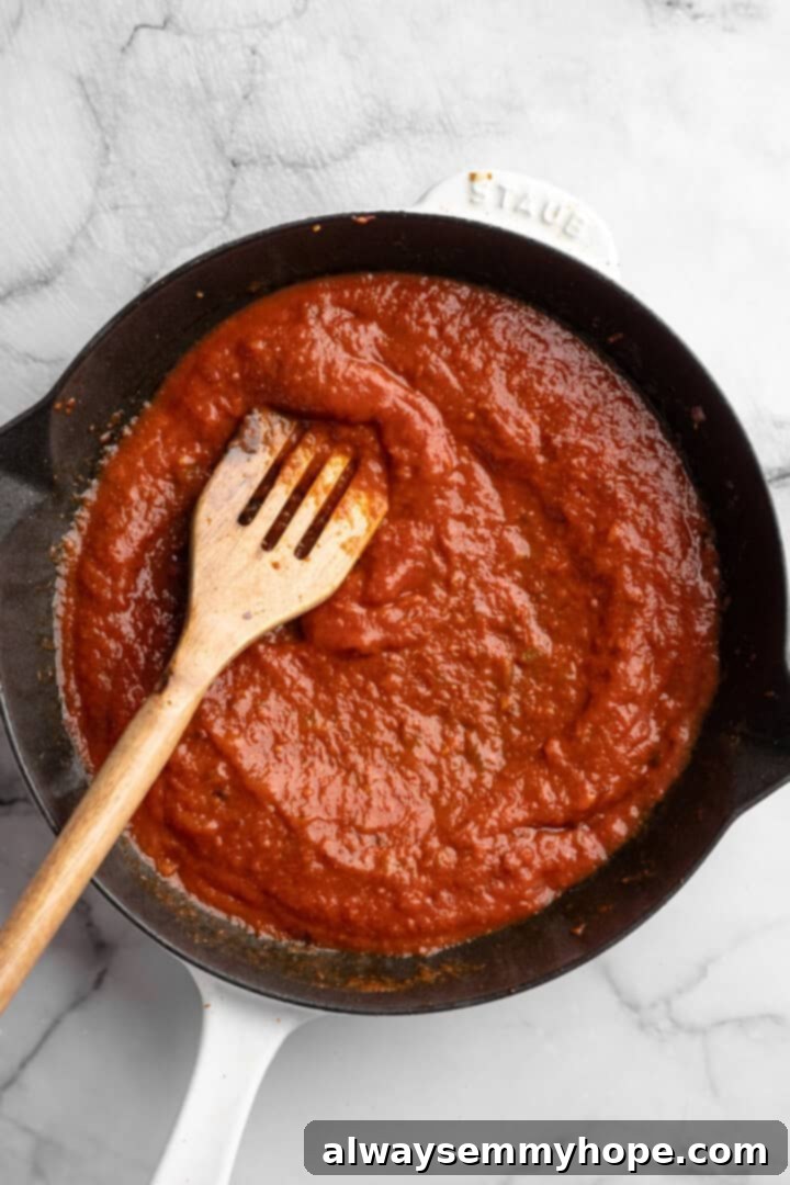 Stirring tomato sauce in skillet