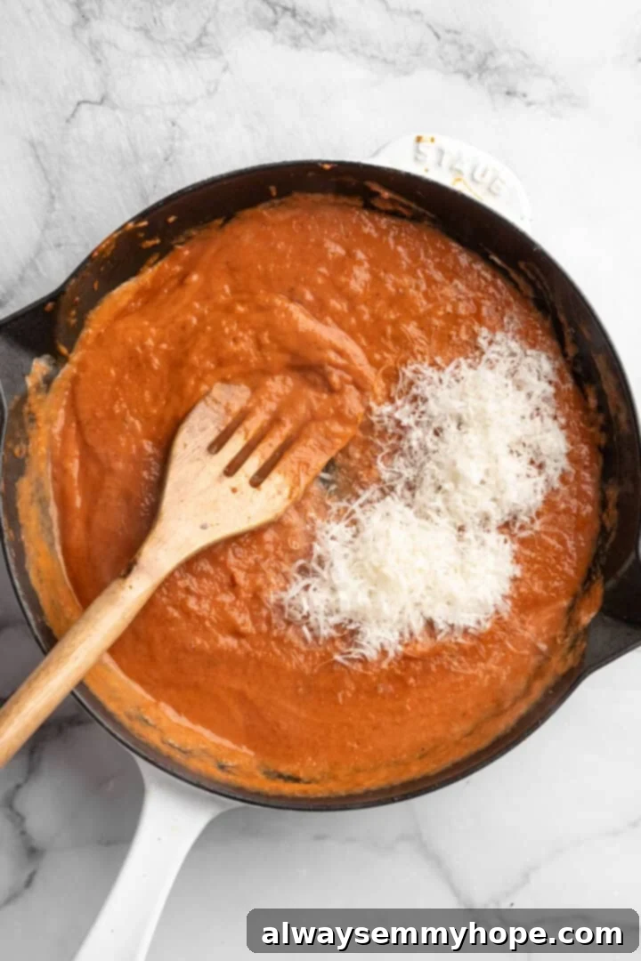 Vegan cheese added to pan of tomato sauce