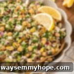 Jennifer Aniston salad in serving bowl with lemon wedges