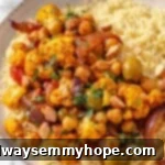 Bowl of couscous topped with Moroccan cauliflower tagine.