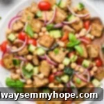 This Chickpea Panzanella Salad pairs crispy cubes of bread with chickpeas, veggies, and a zippy mustard balsamic vinaigrette. It’s a salad that eats like a meal!